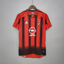 Camisa retrô do AC Milan Away 04/05, com listras vermelhas e pretas, patrocínio da Opel e logo da Adidas.