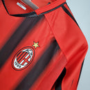 Camisa retro AC Milan Away 04/05 em vermelho e preto com o emblema do clube e detalhes em malha.
