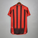Camisa retro AC Milan Away 04/05, atrás com listras verticais vermelhas e pretas.