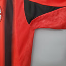 Detalhe da camisa AC Milan Away 04/05 Retro Olympic em vermelho, mostrando a malha e design do tecido.