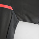 Detalhe da camisa AC Milan Away 11/12 Retro Olympic, mostrando a parte preta e a faixa vermelha.