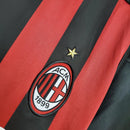 Detalhe do escudo do AC Milan na camiseta retro 09/10, com listras vermelho e preto e estrela.