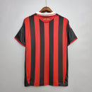 Camisa retrô do AC Milan, modelo 09/10, com listras vermelhas e pretas, vista de trás.