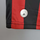 Detalhe da camiseta AC Milan Home 09/10 com logo Adidas, destacando as cores tradicionais vermelho e preto.