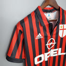 AC Milan Home 99/00 Retro Olympic – Camisola de futebol com listras vermelhas e pretas, logo da Adidas e Opel.