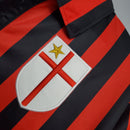 Detalhe do escudo da camisa AC Milan Home 99/00 Retro Olympic com listras vermelhas e pretas.