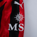 Detalhe da camisola do AC Milan 24/25 com logo da Puma e emblema do clube.