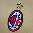 Logo do AC Milan em amarelo com a estrela acima, representando o terceiro uniforme da temporada 13/14.