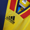 Detalhe da camisa Arsenal Home 93/94, mostrando o logotipo Adidas e as cores vibrantes da retro Olympic Store.