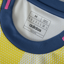 Camisolas Juventus away 24/25 amarelo, detalhe do colarinho e etiqueta adidas.