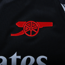 Detalhe do logo do Arsenal no uniforme reserva 24/25, destacando o estilo e a qualidade do Arsenal away.