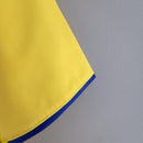 Detalhe da camisa Arsenal Home 93/94 Retro com gola azul e tecido amarelo vibrante.