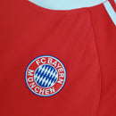 Logo do Bayern München em camisa vermelha retro 00/01, destacando a tradição do clube.