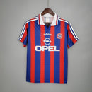 Camisa retrô do Bayern München de 1995, com as cores vermelho e azul, marca Adidas e logo da Opel.