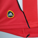 Detalhe do símbolo da adidas em camisa Bayern München Home 2010 Retro, destacando qualidade e design icônicos.