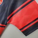 Detalhe da manga do uniforme Bayern München Home 97/98 Retro, mostrando o design vermelho e preto.
