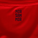 Detalhe da parte de trás da camisa do Bayern München, com a inscrição 'MIA SAN MIA' em um fundo vermelho.