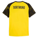 Camiseta Borussia Dortmund 25/26, amarela, com detalhes em preto nas mangas, exibindo o nome Dortmund nas costas.