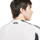 Camisola Principal Newcastle United 2025/26 Adidas com listas verticais pretas e brancas, detalhes em azul e inscrição “Howay the Lads” na nuca.