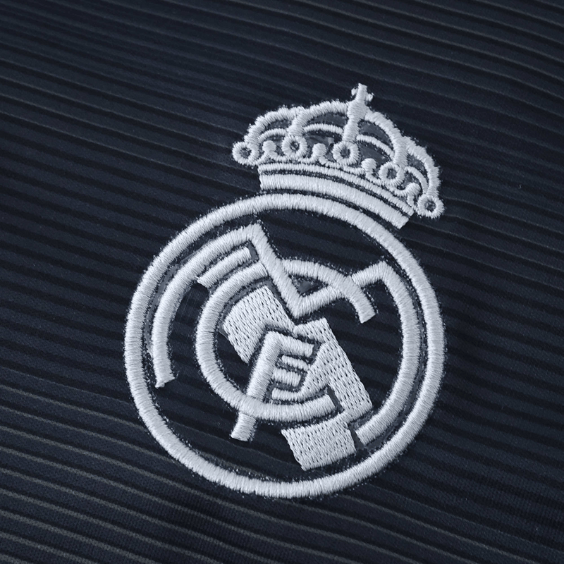 Camisola reserva do Real Madrid 2025/26 da Adidas, em azul-marinho com detalhes prateados e linhas verde fluorescente, sobre fundo branco.