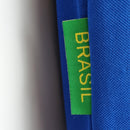 Camisola Brasil Away 1998 Retro com etiqueta verde Brasil visível em fundo azul.