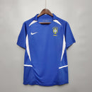 Camisola Brasil Away 2002 Retro, camiseta de futebol azul com detalhes brancos, logo da Nike e escudo do Brasil.