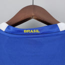 Camisola Brasil Away 2006 Retro com gola na cor azul e detalhe em amarelo que exibe a palavra 'BRASIL'.