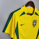 Camisola Brasil Home 2002 Retro amarela com detalhes em verde e logo da Nike.