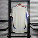 Camisola França away 2006 Retro, vista traseira em fundo neutro, destaque para as cores azul e vermelho.