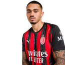 Camisola principal do AC Milan 2025/26 com riscas vermelhas e pretas estilizadas em forma de chamas, gola preta e escudo em vermelho e branco