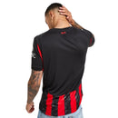 Camisola principal do AC Milan 2025/26 com riscas vermelhas e pretas estilizadas em forma de chamas, gola preta e escudo em vermelho e branco