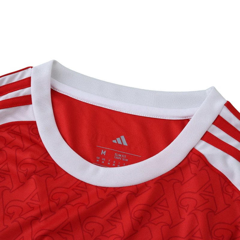 Camisola principal do Arsenal 2025/26 da Adidas, em vermelho com mangas brancas e padrão gótico subtil com a letra “A”, gola redonda e logos em branco.
