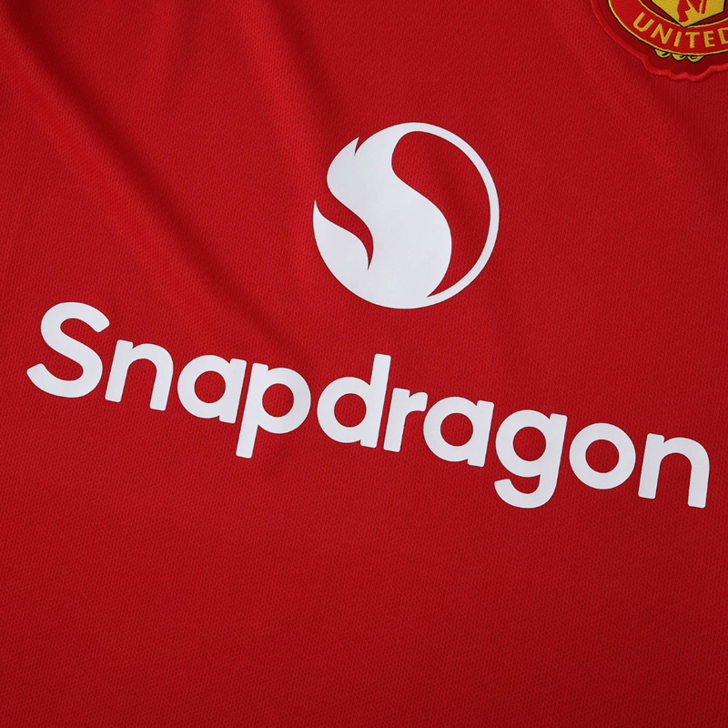 Camisola principal do Manchester United 2025/26 Adidas vermelha com detalhes pretos e brancos, padrão abstrato nos ombros e inscrição “Theatre of Dreams” nas costas.