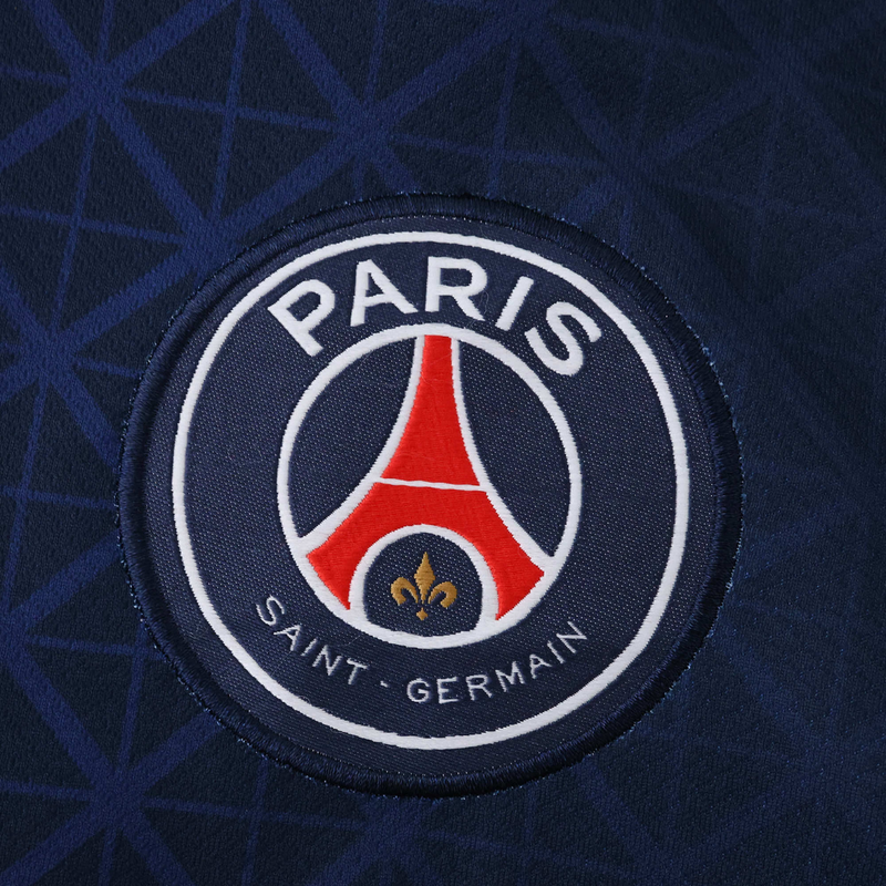 Camisola principal do PSG 2025/26 Nike azul-marinho com faixa central vermelha e branca, padrão inspirado na Torre Eiffel e gola V assimétrica.