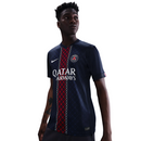 Camisola principal do PSG 2025/26 Nike azul-marinho com faixa central vermelha e branca, padrão inspirado na Torre Eiffel e gola V assimétrica.