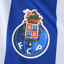 Camisola principal do FC Porto 2025/26, com riscas verticais azul e branco, detalhes dourados e gola redonda, criada pela New Balance.