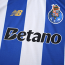 Camisola principal do FC Porto 2025/26, com riscas verticais azul e branco, detalhes dourados e gola redonda, criada pela New Balance.