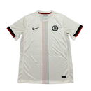 Camisola secundária Chelsea 2025/26 Nike branca, com faixa vertical laranja e preta ao centro, gola redonda branca e detalhes inspirados nos anos 70.