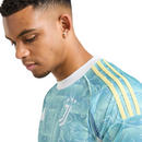 Camisola secundária da Juventus 2025/26 Adidas em azul celeste, com detalhes brancos e amarelos, logótipos em branco e efeito líquido inspirado no Mediterrâneo.