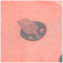 Camisola secundária FC Porto 2025/26 da New Balance, salmão com padrão floral e detalhes em cinzento, escudo e logótipos em tons harmoniosos.