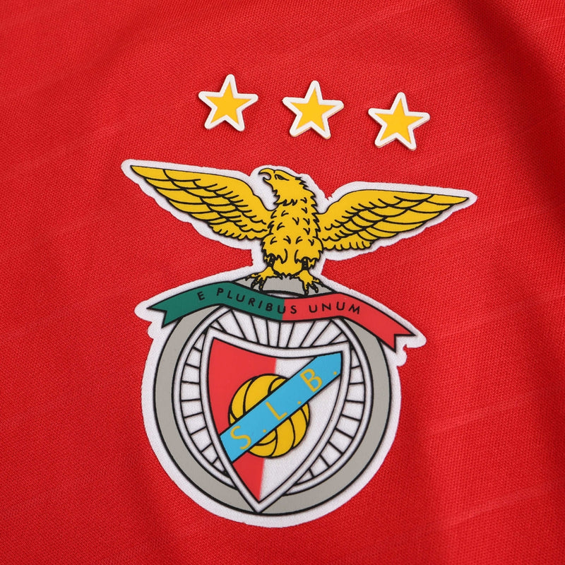 Camisola titular do Benfica 2024/25 com chevrons em relevo, gola em V branca, fundo vermelho encarnado e detalhes em branco no escudo, Adidas e patrocinadores.