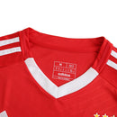 Camisola titular do Benfica 2024/25 com chevrons em relevo, gola em V branca, fundo vermelho encarnado e detalhes em branco no escudo, Adidas e patrocinadores.