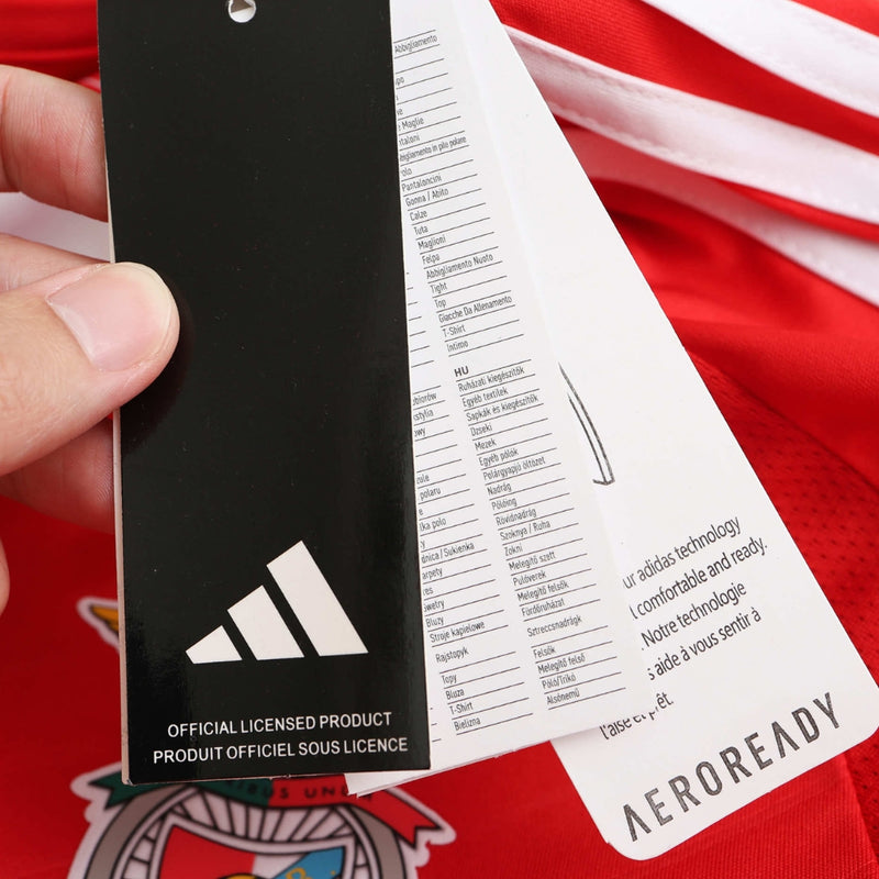 Camisola titular do Benfica 2024/25 com chevrons em relevo, gola em V branca, fundo vermelho encarnado e detalhes em branco no escudo, Adidas e patrocinadores.