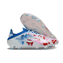 Chuteira Adidas F50 FG Elite Ed. "Bape" com design camuflado em azul e vermelho.