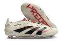 Chuteira Adidas Predator Elite FG - Bege, Preta e Vermelha em ângulo com sola exposta para destaque em gramados.