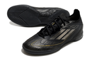 Chuteira Futsal Adidas F50 IC Preta com design minimalista e tecnologia de aderência para quadras interiores.