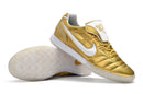 Chuteira Futsal Tiempo Legend Elite IC "Ronaldinho" Dourada, design elegante em dourado com detalhes em branco.