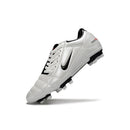 Chuteira Nike Total 90 FG Branca e Preta exibida em ângulo, destacando design e tecnologia para desempenho em campo.