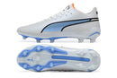 Chuteira Puma King Ultimate FG Branca e Azul vista lateral e inferior, destaque no design e tecnologia.