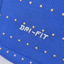 Detalhe da textura e estampa da camisola Brasil, destacando a tecnologia DRI-FIT em azul com bolinhas amarelas.